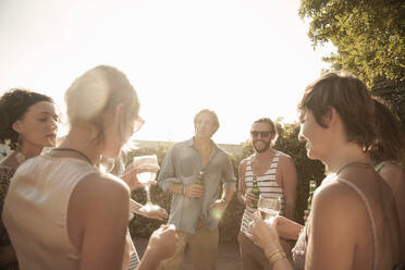 Happy friends enjoying summer while drinking alcohol against sky - AJOF00284