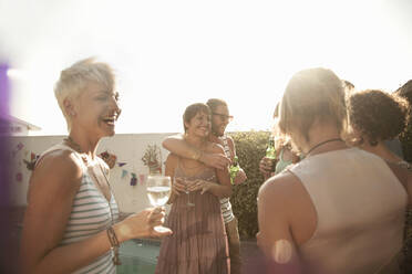 Weibliche und männliche Freunde genießen den Sommer und trinken Alkohol gegen den Himmel - AJOF00286