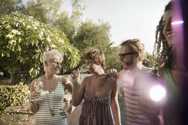 Smiling women and man enjoying party while drinking outdoors - AJOF00287