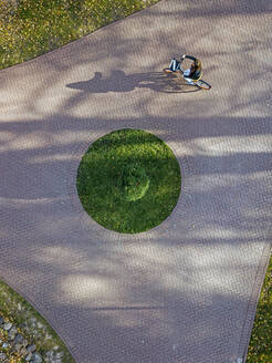 Frau fährt Fahrrad auf dem Fußweg im Park - KNTF05758