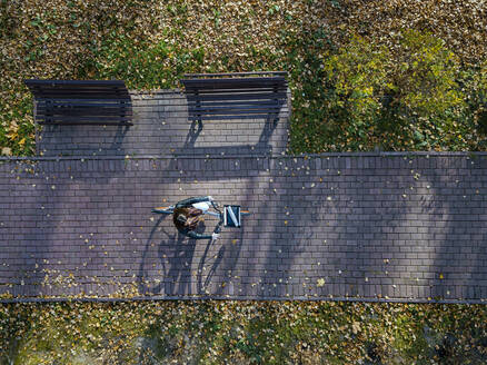 Frau fährt mit dem Fahrrad auf einem Fußweg im Park im Herbst - KNTF05762