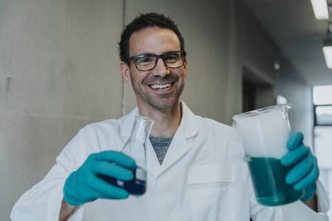 Scientist standing with liquid solution at clinic corridor stock photo