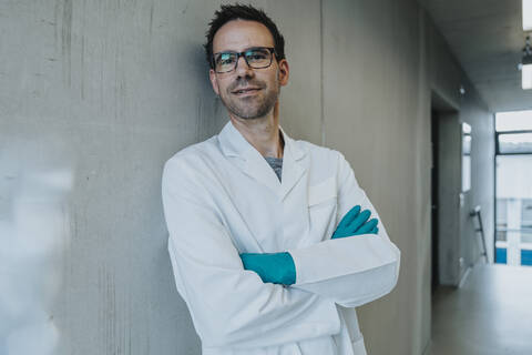 Scientist leaning on wall at clinic corridor stock photo