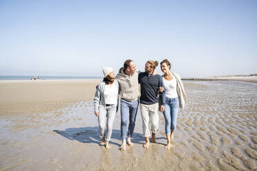 Family talking while walking together at beach - UUF21705