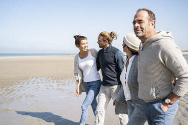 Smiling couples walking together at beach - UUF21725