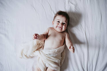 Cute baby boy lying on bed at home - EBBF00872