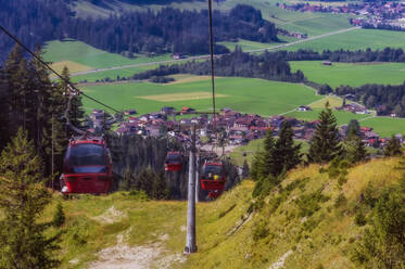 Österreich, Tirol, Gran, Skilift im Tannheimer Tal mit Dorf im Hintergrund - THAF02928