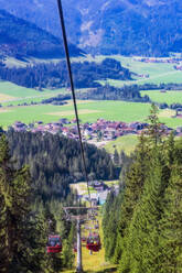 Österreich, Tirol, Gran, Skilift im Tannheimer Tal mit Dorf im Hintergrund - THAF02929