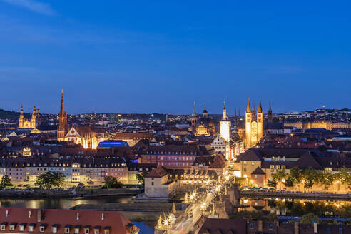 Deutschland, Bayern, Würzburg, Alte Mainbrucke und umliegende Altstadtgebäude in der Abenddämmerung - WDF06330