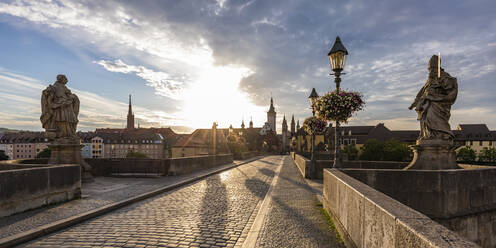 Deutschland, Bayern, Würzburg, Leere Alte Mainbrücke bei bewölktem Sonnenuntergang - WDF06334