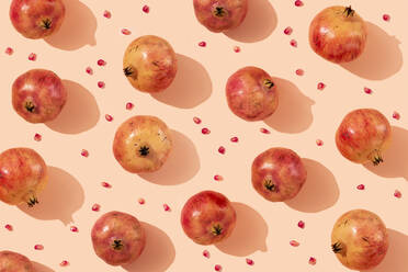 Ripe pomegranates with seeds arranged on beige background - GEMF04249
