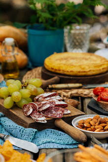 Verschiedene leckere Speisen auf einem schäbigen Holztisch im Erholungsgebiet für ein Picknick im Valle del Jerte - ADSF16836