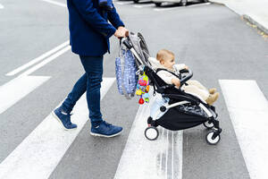 Man with baby stroller crossing road in city - PGF00153