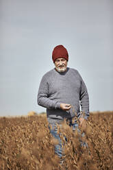 Landwirt prüft die Ernte bei einem Spaziergang auf einem Bauernhof gegen den klaren Himmel - ZEDF03961