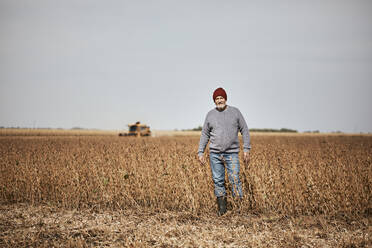 Farmer standing in soybean farm against clear sky - ZEDF03963