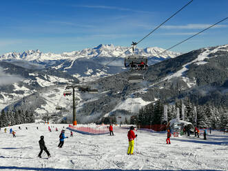 Österreich, Salzburg, Skifahrer und Skilift in schneebedeckten Bergen - WWF05459