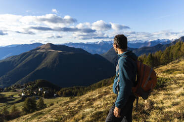 Tourist mit Rucksack, der den Berg an einem sonnigen Tag betrachtet - MCVF00628