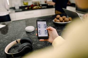 Hohe Winkel Ansicht des Mädchens mit Handy am Küchentisch - MASF20022