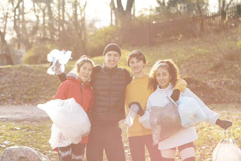Lächelnde Umweltschützerinnen und Umweltschützer mit Mikroplastikmüll im Park - MASF20048