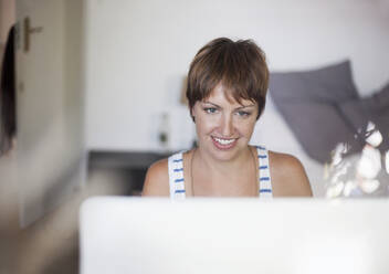 Young woman working on computer at home - AJOF00317