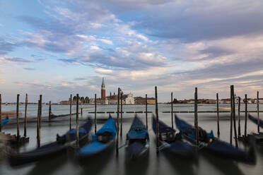 Italy, Veneto, Venice, Gondolas moored in marina with San Giorgio Maggiore in background - FCF01894
