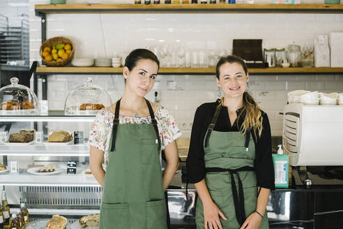 Lächelnde Frauen stehen an der Theke eines Cafés - XLGF00618