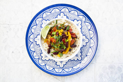 Schüssel mit mexikanischem Reis, Tomaten, Paprika, Tofu, Kidneybohnen, Mais, Frühlingszwiebeln und Limette - LVF09034