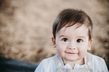 Cute baby smiling while sitting outdoors - EBBF00970