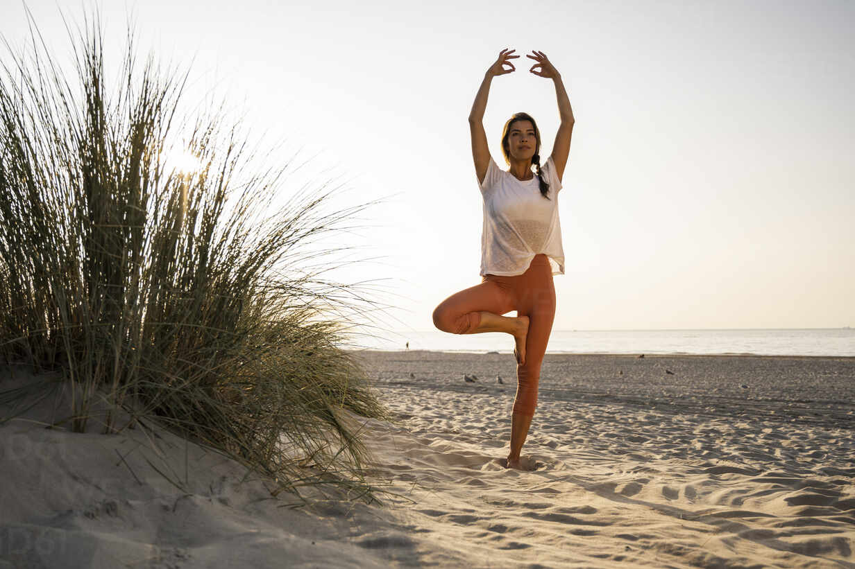 Premium Photo | Beautiful woman doing yoga pose at sunset beach