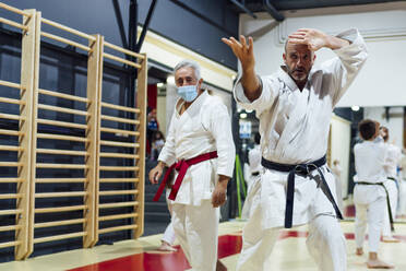 Instructor by male student practicing karate in class - OCMF01792