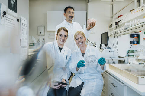 Team of scientist holding glass sample and anatomy of human brain at laboratory stock photo