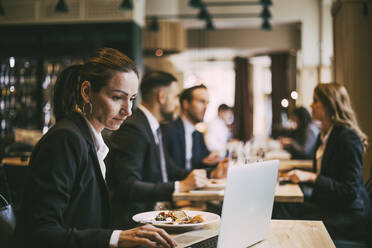 Seitenansicht einer Geschäftsfrau mit Laptop im Restaurant - MASF20071