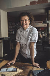 Porträt eines lächelnden reifen Kochs in einem Restaurant - MASF20115
