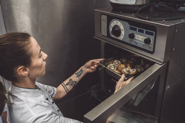 Hohe Winkel Ansicht der weiblichen Koch Backen Pilze im Ofen - MASF20142