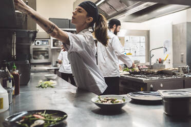 Female chef working in commercial kitchen - MASF20149