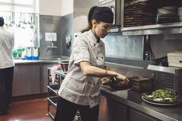 Male and female chefs preparing food in commercial kitchen at restaurant - MASF20155