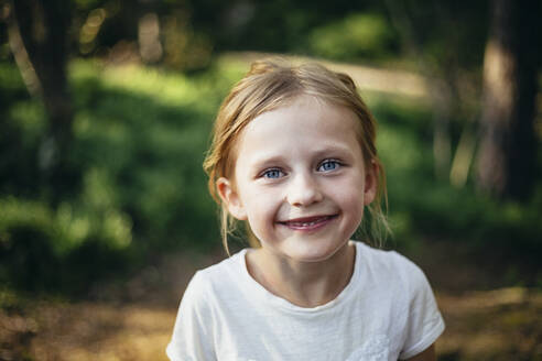 Porträt eines süßen lächelnden Mädchens im Wald stehend - MASF20171
