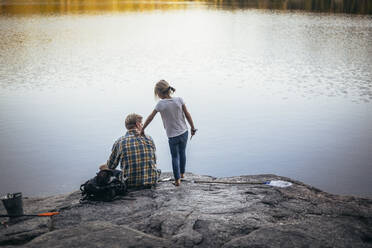 Rückansicht von Vater und Tochter beim Angeln am See - MASF20212