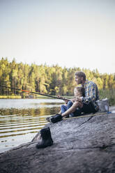 Father and daughter fishing at lake during weekend - MASF20220