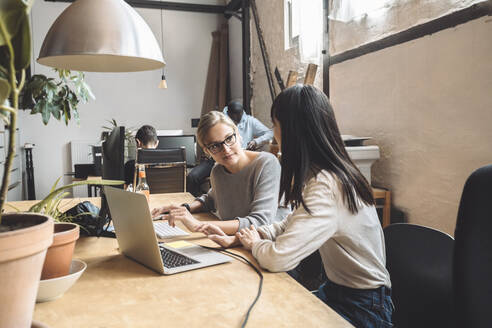 Female computer programmers discussing at place of work - MASF20348