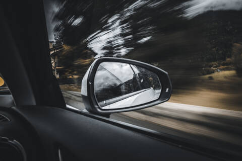Side-view mirror reflection of moving car stock photo