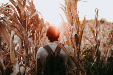 Mann mit Rucksack auf einem landwirtschaftlichen Feld - EBBF01041