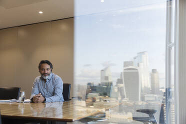 Porträt eines selbstbewussten Geschäftsmanns in einem Konferenzraum in einem Hochhaus, London, UK - CAIF29711