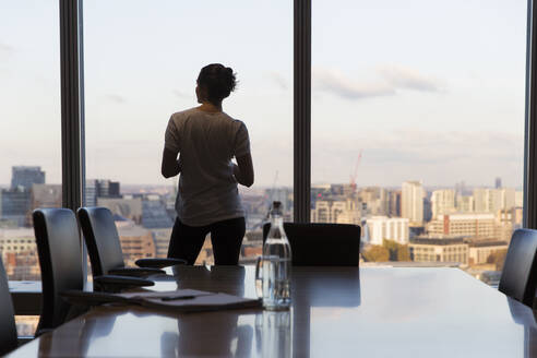 Thoughtful businesswoman looking out highrise office window - CAIF29721