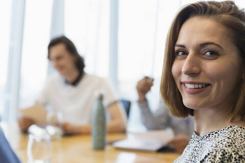 Porträt einer selbstbewussten lächelnden Geschäftsfrau in einer Besprechung, lizenzfreies Stockfoto