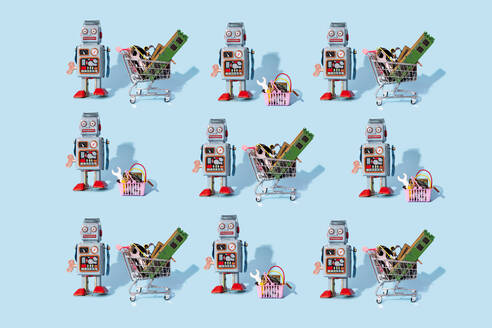 Muster eines alten Spielzeugroboters, der neben Miniatur-Einkaufswagen und Körben mit elektronischen Geräten steht - GEMF04269