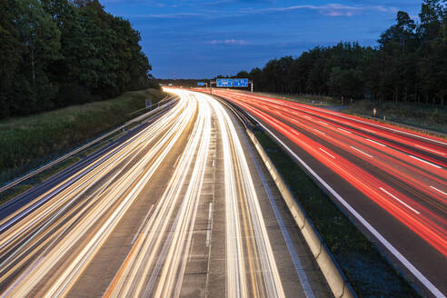 Deutschland, Baden-Württemberg, Stuttgart, Fahrzeug-Lichtspuren auf der Bundesautobahn 8 in der Abenddämmerung - WDF06340