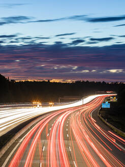 Deutschland, Baden-Württemberg, Stuttgart, Fahrzeug-Lichtspuren auf der Bundesautobahn 8 in der Abenddämmerung - WDF06341