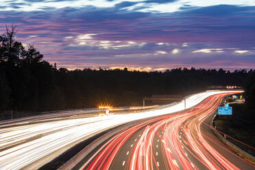 Deutschland, Baden-Württemberg, Stuttgart, Fahrzeug-Lichtspuren auf der Bundesautobahn 8 in der Abenddämmerung - WDF06342