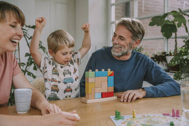 Mutter und Vater spielen mit fröhlichem Sohn Spielzeug-Block-Puzzle zu Hause - MFF06655
